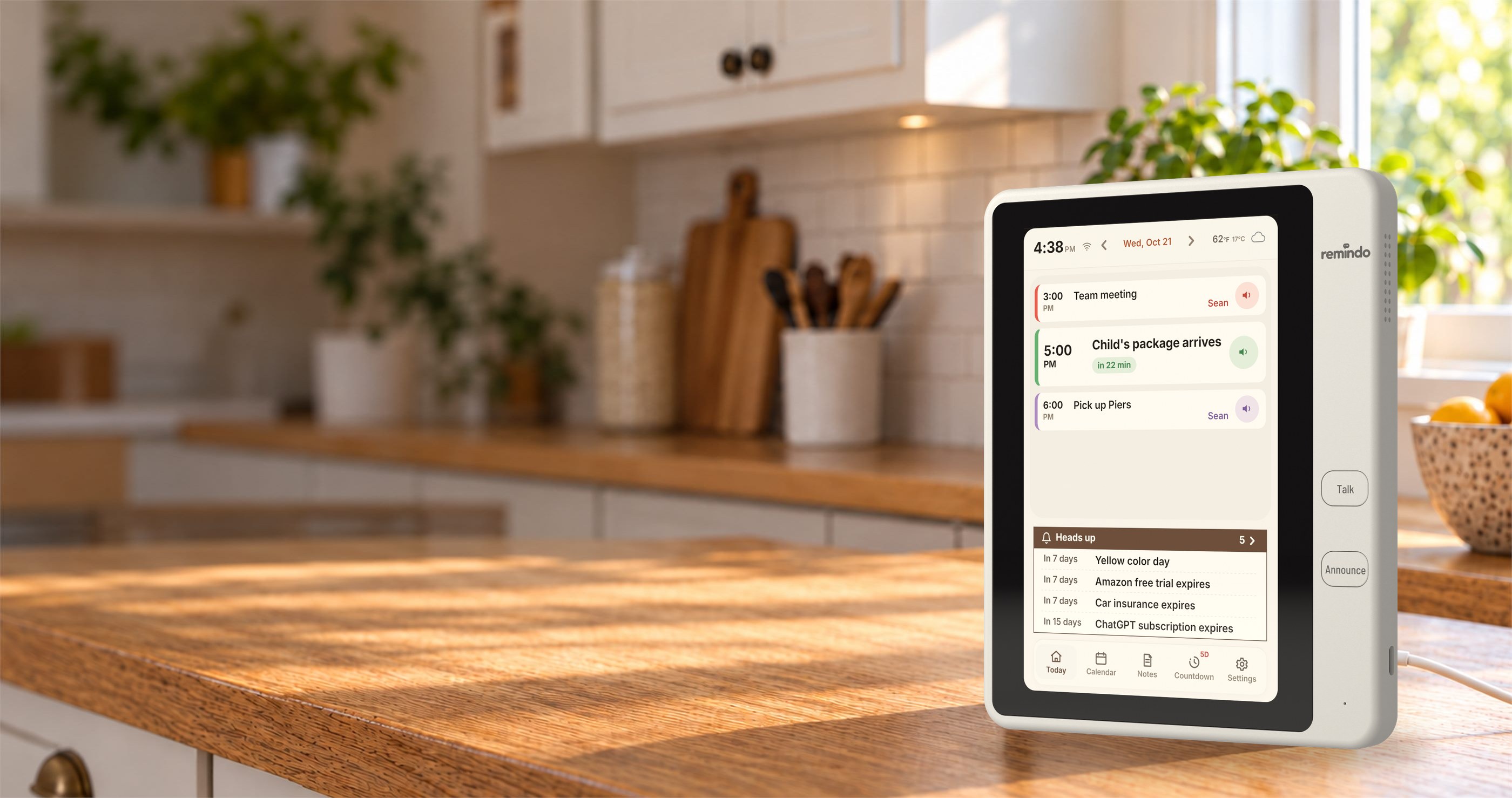 Remindo, a white countertop family calendar with an 8-inch screen and Talk and Announce buttons, on a kitchen counter. Press. Say it. Hear it when it's time. No App, No Account, No Camera, No Subscription.